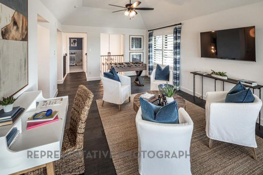 Living area featuring vaulted ceiling, a ceiling fan, and wood finished floors Living area featuring vaulted ceiling, a ceiling fan, and wood finished floors