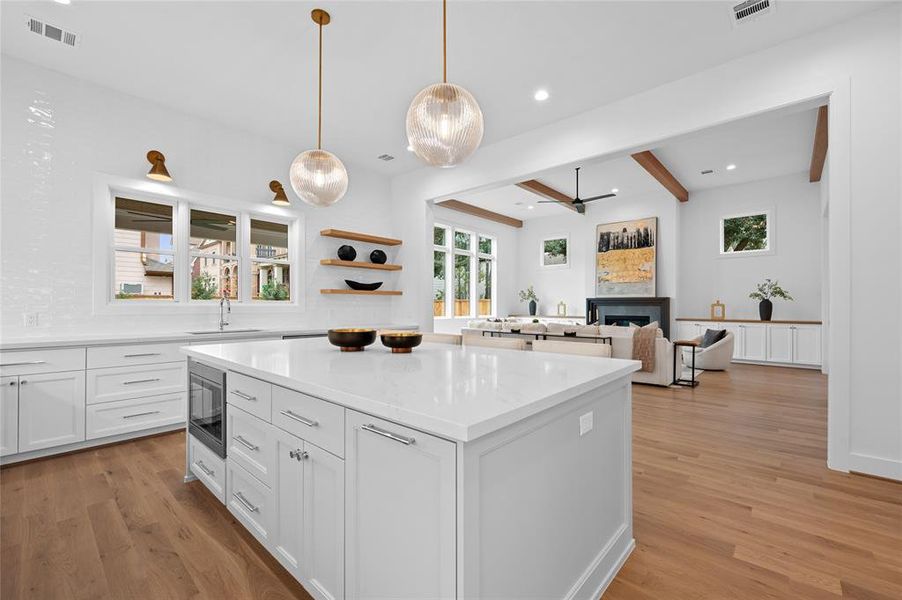 Open floor plan with huge great room with 13' ceiling and white oak wood beam ceiling detail open to dining room and kitchen overlooking backyard