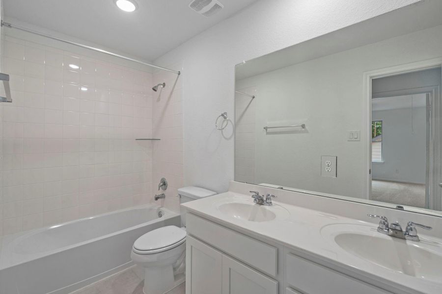 The secondary bath features tile flooring, white cabinetry and light countertops and a shower/tub combo. Perfect for accommodating any visiting family and friends. The secondary bath features tile flooring, white cabinetry and light countertops and a shower/tub combo. Perfect for accommodating any visiting family and friends.