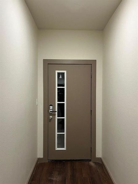 Doorway to outside with wood finished floors and elevator Doorway to outside with wood finished floors and elevator