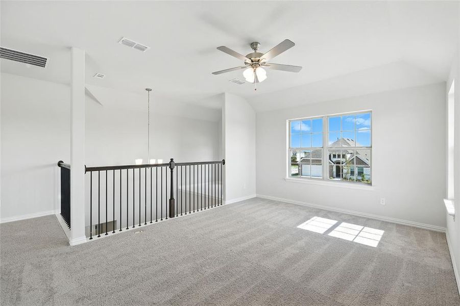 Carpeted empty room featuring a ceiling fan, vaulted ceiling, and a chandelier Carpeted empty room featuring a ceiling fan, vaulted ceiling, and a chandelier