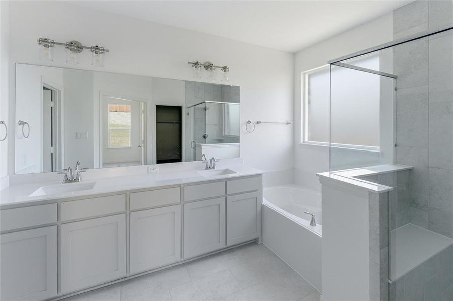Bathroom with double vanity, a stall shower, a bath, and light tile patterned flooring