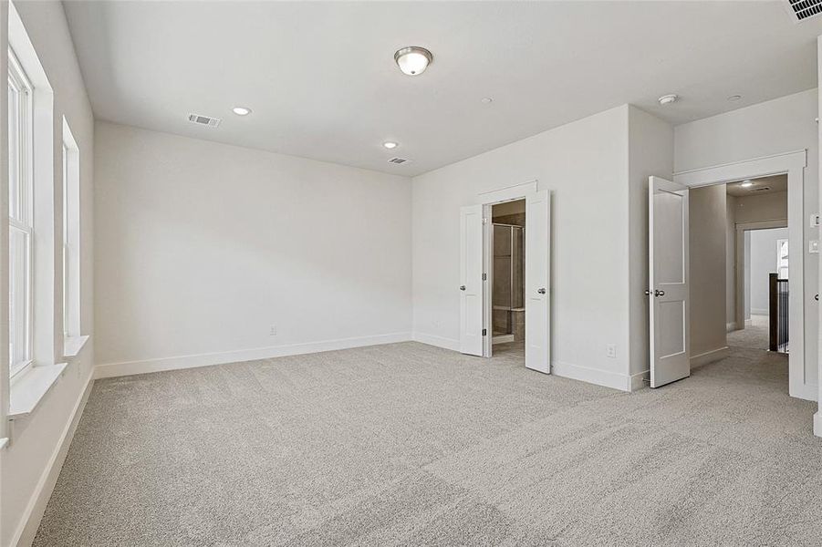 Unfurnished bedroom with light carpet, recessed lighting, and ensuite bathroom