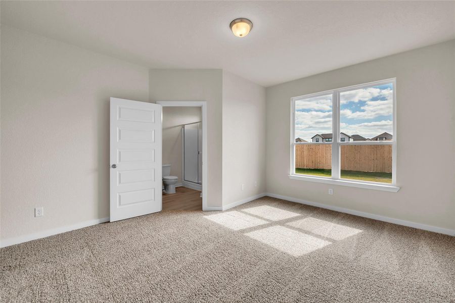 Empty room with light colored carpet and baseboards
