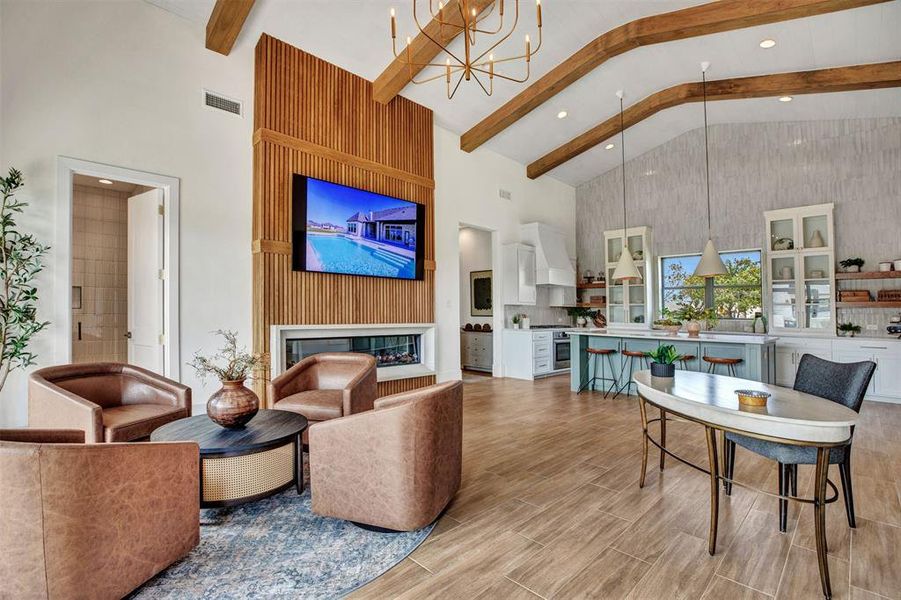 Living area with high vaulted ceiling, beamed ceiling, wood finish floors, a chandelier, and a glass covered fireplace Living area with high vaulted ceiling, beamed ceiling, wood finish floors, a chandelier, and a glass covered fireplace