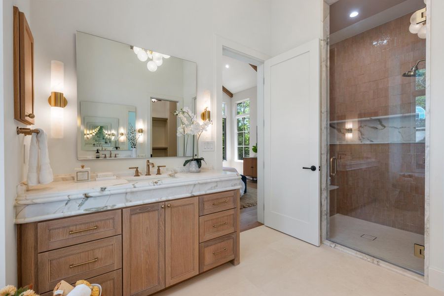 Custom cabinetry and elegant stone countertops define this sophisticated master bath sanctuary.