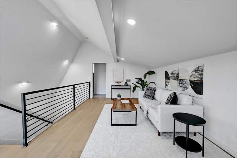 Living room with light wood-type flooring and vaulted ceiling