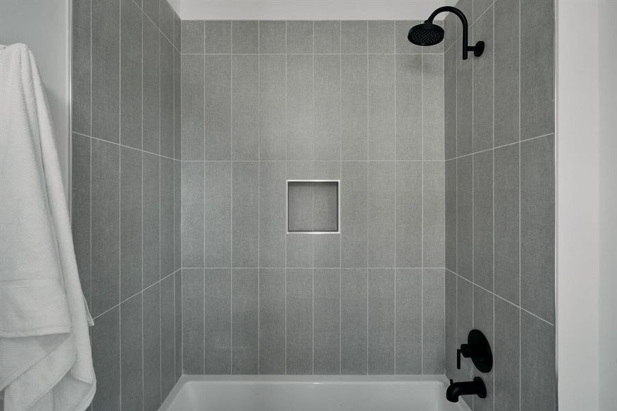 Bathtub-shower combination featuring a matte black showerhead and faucet