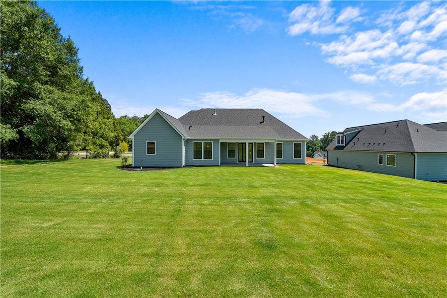 A spacious lawn extends from the home's rear, offe