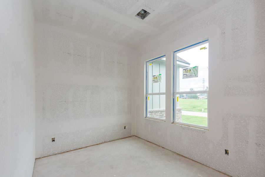 Bright, unfinished bedroom with large windows offering natural light and views of the surrounding greenery, ready for customization to suit your needs. Bright, unfinished bedroom with large windows offering natural light and views of the surrounding greenery, ready for customization to suit your needs.