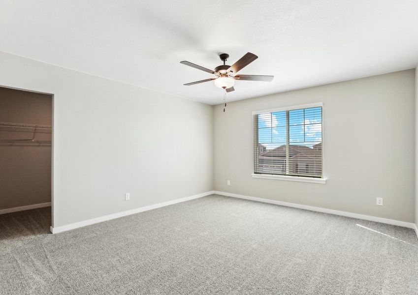 The master bedroom is spacious and a ceiling fan.