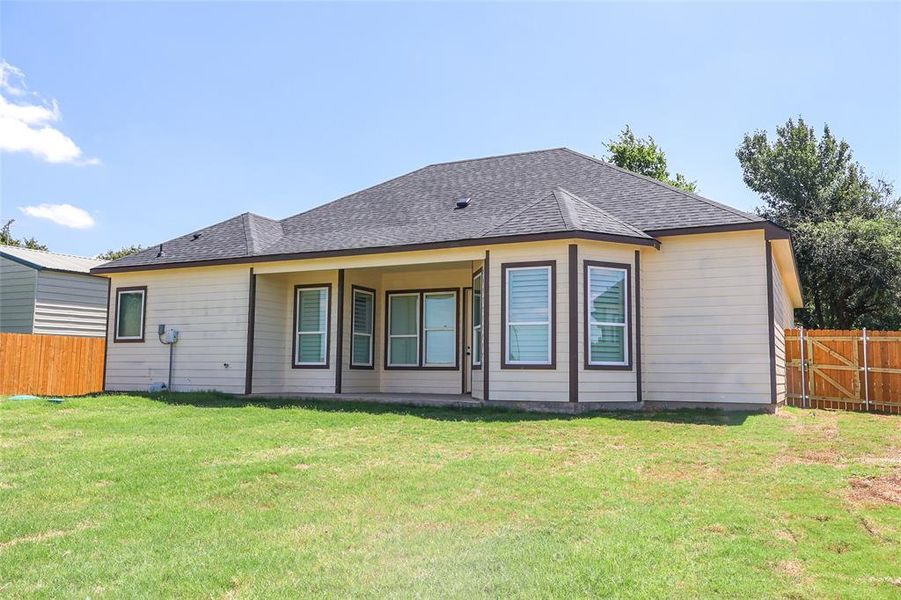 Rear view of property featuring roof with shingles