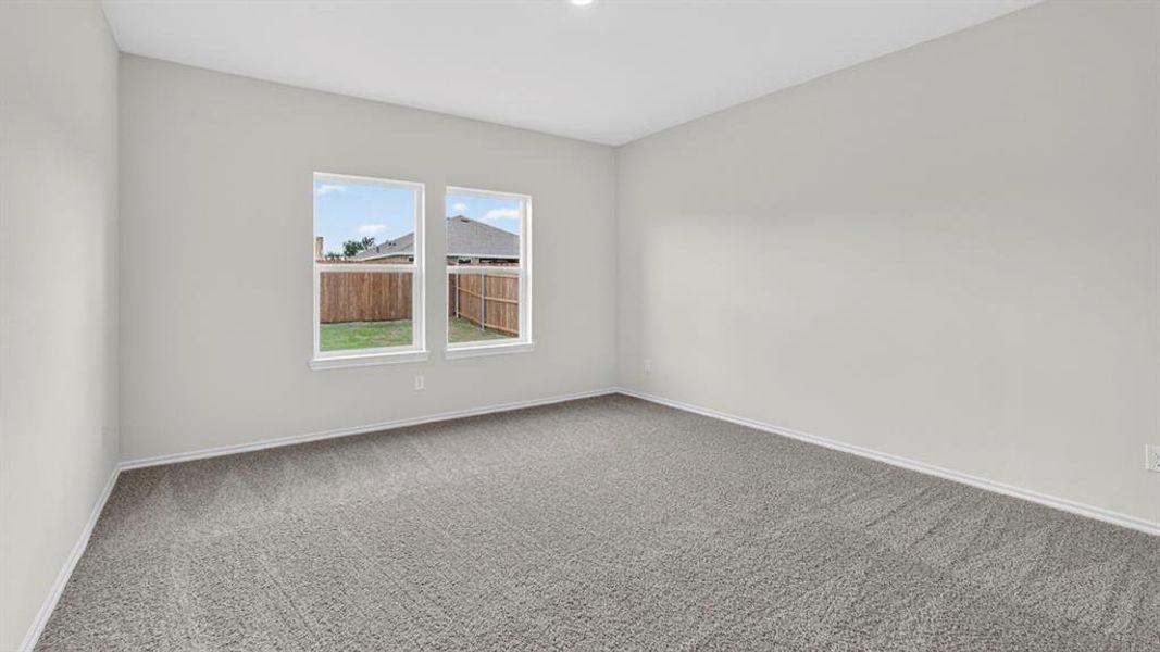 Spacious room featuring neutral tone carpeting and light gray wall paint Spacious room featuring neutral tone carpeting and light gray wall paint