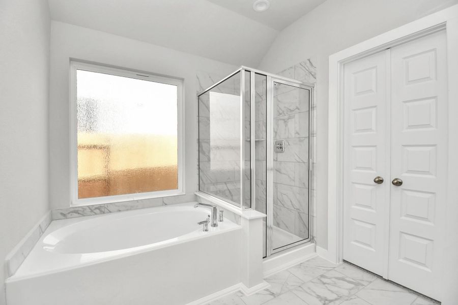 Escape to a spa-like oasis in this primary bathroom. Enjoy a walk-in showerwith tile surround, a separate garden tub with custom detailing, and an elegantvanity featuring light countertops, modern hardware, and beautiful recessed lights.Experience luxury and relaxation in every detail!