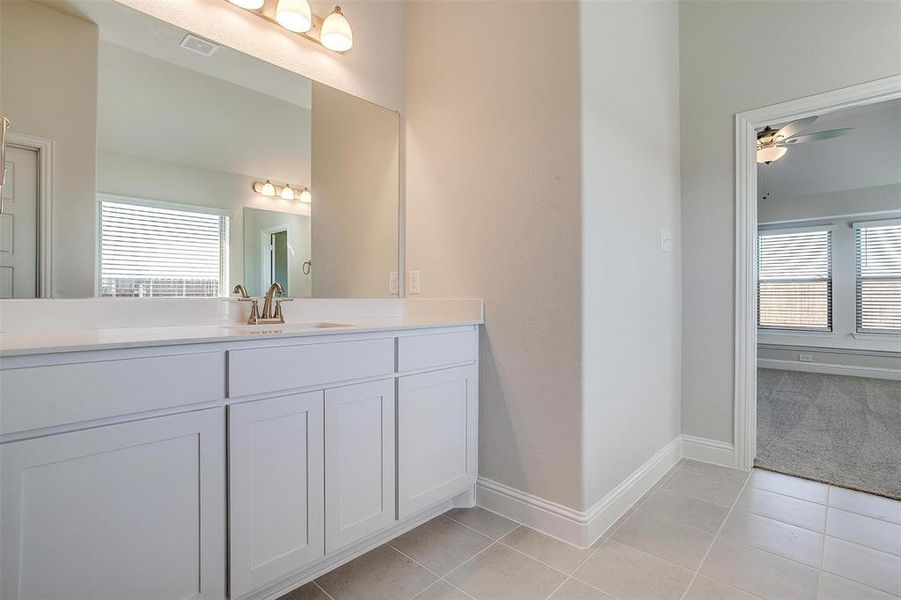 Bathroom with tile patterned flooring, vanity, and ceiling fan