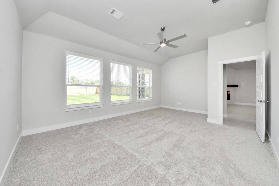 Come and unwind after a long day in this magnificent primary suite! This spacious room features plush carpet, warm paint, high ceilings and large windows with privacy blinds. Sample photo of completed home with similar floor plan. Actual colors and selections may vary.