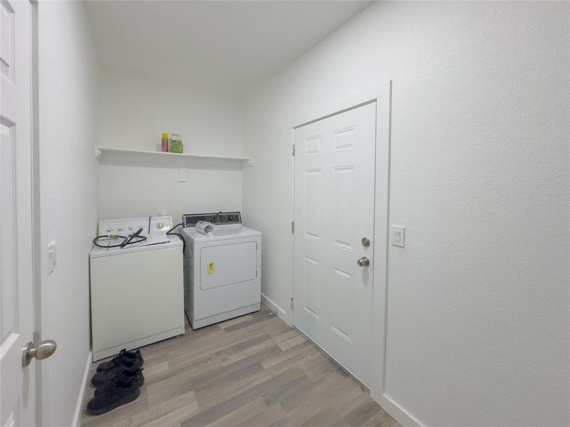 Washroom featuring light hardwood / wood-style floors and washing machine and clothes dryer