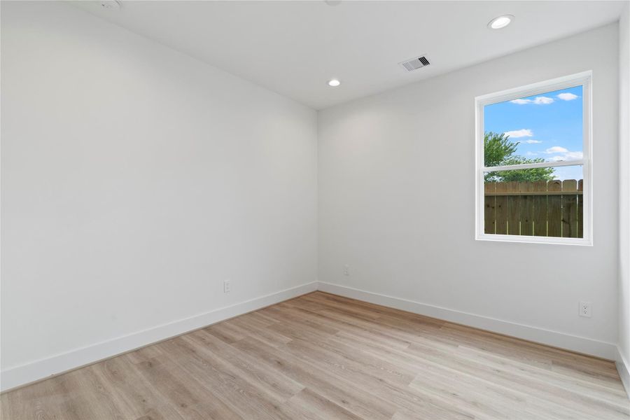 Spacious guest bedroom featuring a private ensuite bath with a walk-in shower. Spacious guest bedroom featuring a private ensuite bath with a walk-in shower.