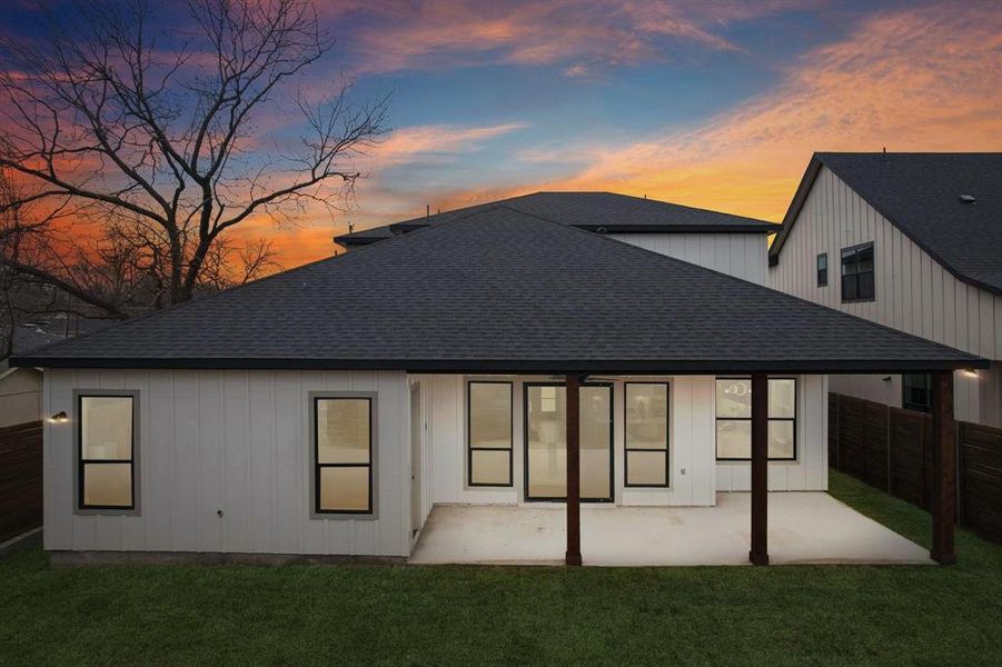 The property features a private yard with a covered patio area and a well-maintained lawn