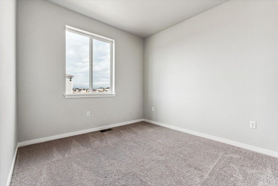 A room with a window and a carpet.