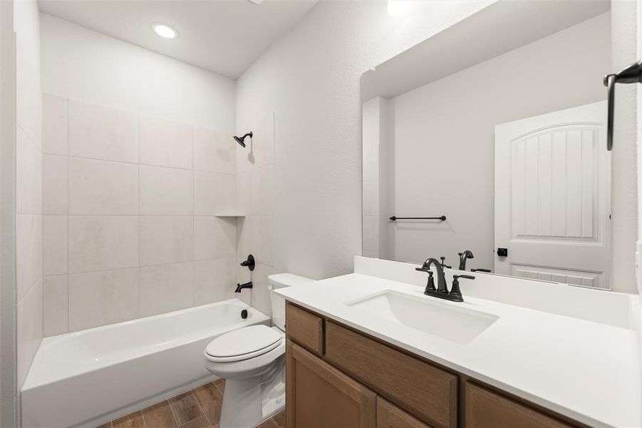 Full bath featuring tub / shower combination, vanity, wood finish floors, and recessed lighting Full bath featuring tub / shower combination, vanity, wood finish floors, and recessed lighting