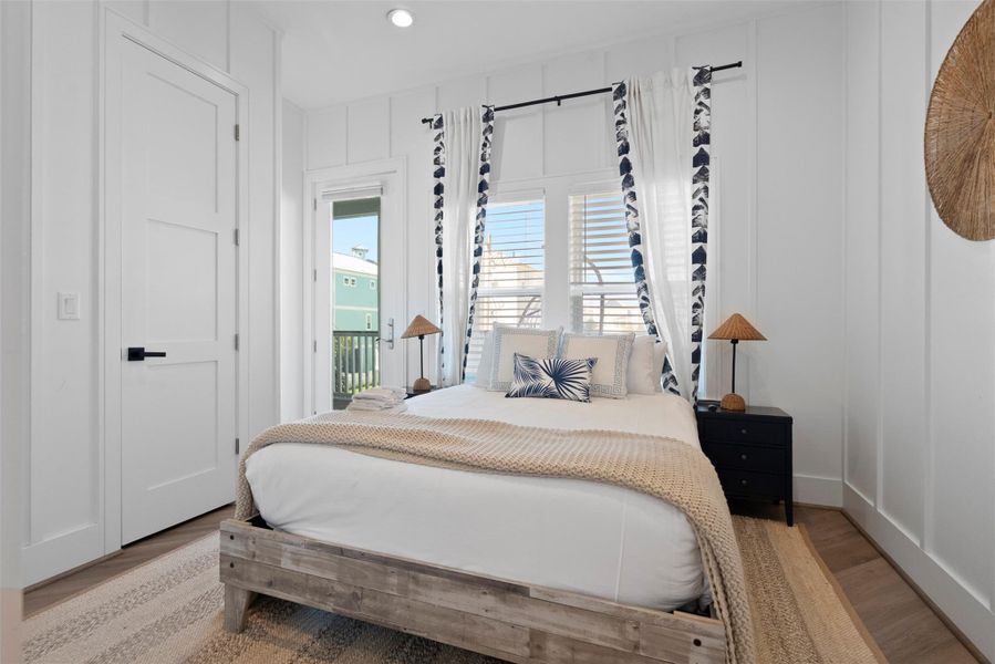 Also on the first floor, this third bedroom invites you to unwind in modern coastal style. Soft neutrals and ocean-inspired tones set a tranquil mood, with a plush bed, natural textures, and a breezy side window enhancing the airy feel. A nearby door offers private access to an en suite bath, while a second entrance opens to the shared balcony—seamlessly connecting to the secondary bedroom for an elevated indoor-outdoor flow. Also on the first floor, this third bedroom invites you to unwind in modern coastal style. Soft neutrals and ocean-inspired tones set a tranquil mood, with a plush bed, natural textures, and a breezy side window enhancing the airy feel. A nearby door offers private access to an en suite bath, while a second entrance opens to the shared balcony—seamlessly connecting to the secondary bedroom for an elevated indoor-outdoor flow.