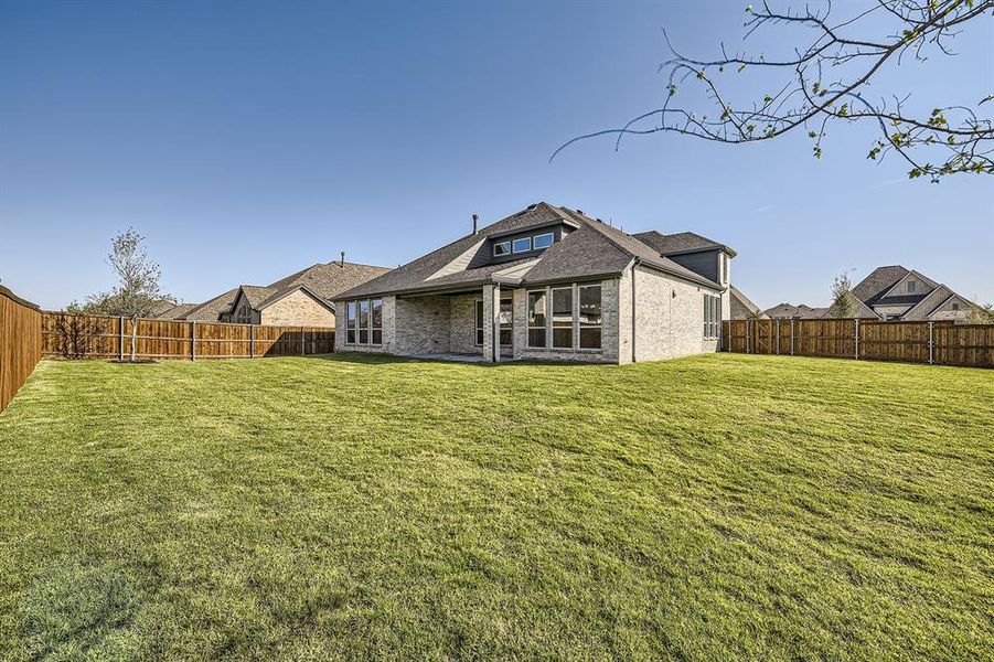 Back of house with a patio area and a lawn