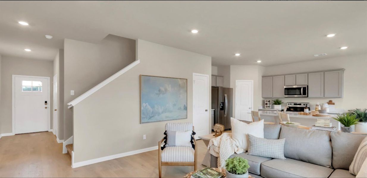 Living room with recessed lighting, light wood-style flooring, and stairway
