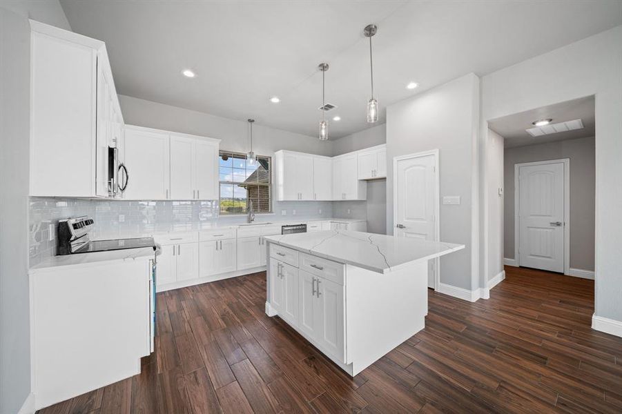 Kitchen with a center island, stove, dark hardwood / wood-style flooring, and white cabinets