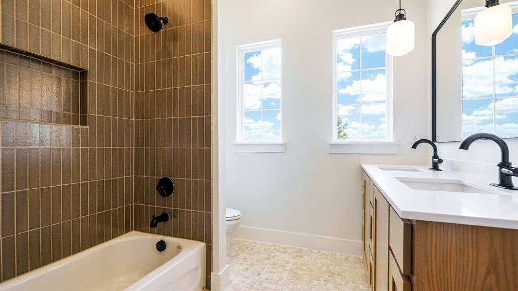 Full bathroom with a healthy amount of sunlight, tile flooring, vanity, and toilet