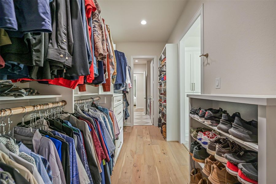 The second customized primary closet continues the exceptional storage with double hanging rods, built-in drawers & shoe shelving, while a connecting passage provides convenient direct access between the primary suite, bath and utility room.