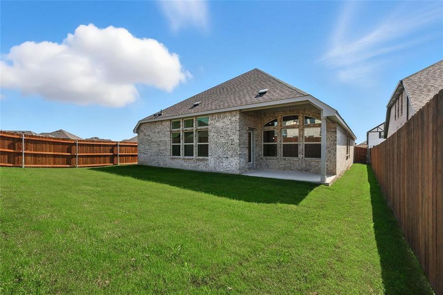 Rear view of property with brick siding, a patio, a fenced backyard, and roof with shingles
