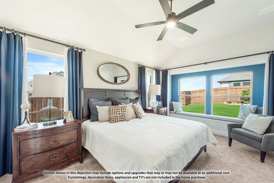 Bedroom with vaulted ceiling, ceiling fan, window seat, blue accent wall, and large windows overlooking backyard