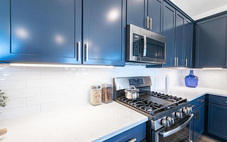 Close up view of the gourmet kitchen showcasing granite countertops, stylish cabinetry, stainless steel gas range, built in microwave, and a clean modern finish, a kitchen that truly serves as the heart of the home. **Photos are representative only and may vary as built.**
