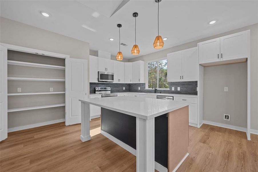 Large pantry with easy access to the kitchen and island.