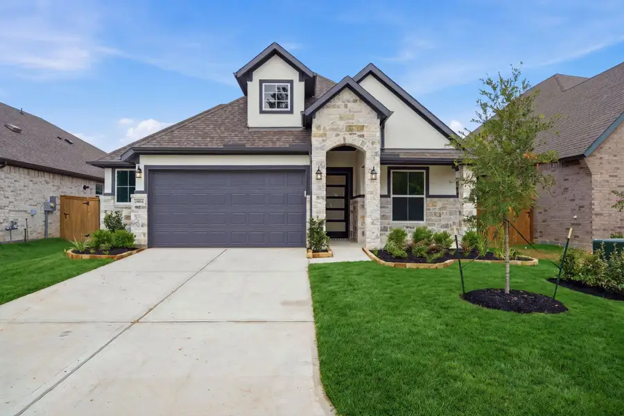 Front exterior of a new home in The Highlands, Porter, TX, highlighting curb appeal (Image 1). Front exterior of a new home in The Highlands, Porter, TX, highlighting curb appeal (Image 1).