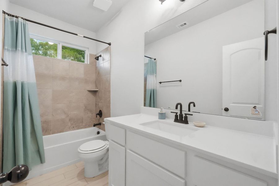 secondary bathroom with tub/shower combo and clean, modern finishes.