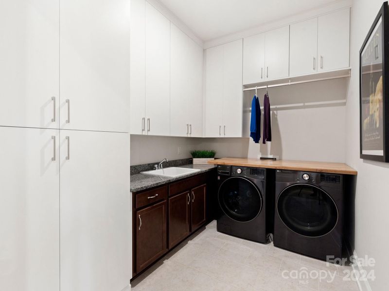 Custom designed laundry room with extensive storage and sink