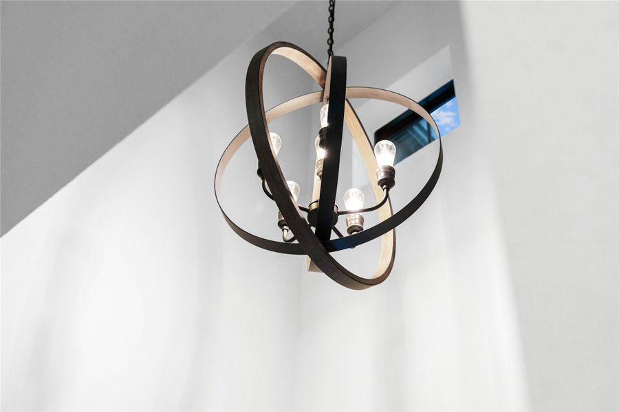 This farmhouse-style orb chandelier features a striking open-sphere frame of rustic wood bands and black metal, encircling a central multi-light candelabra for a bold and sophisticated architectural statement.