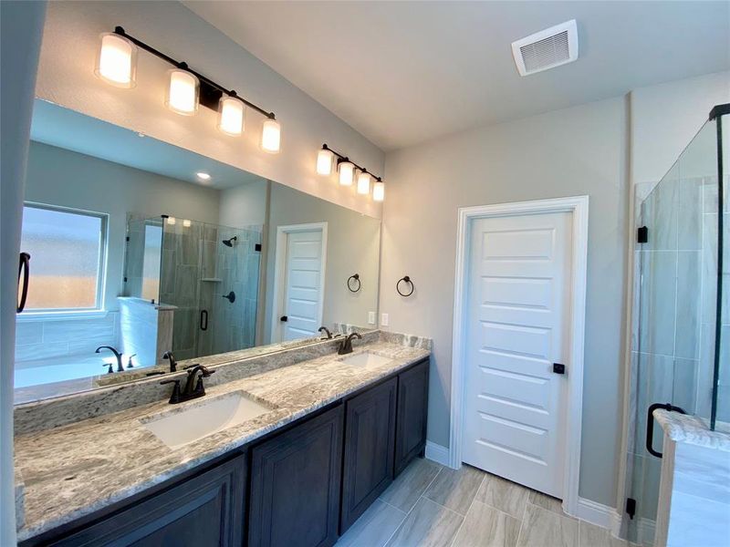 Master bath has dual sinks on granite vanity