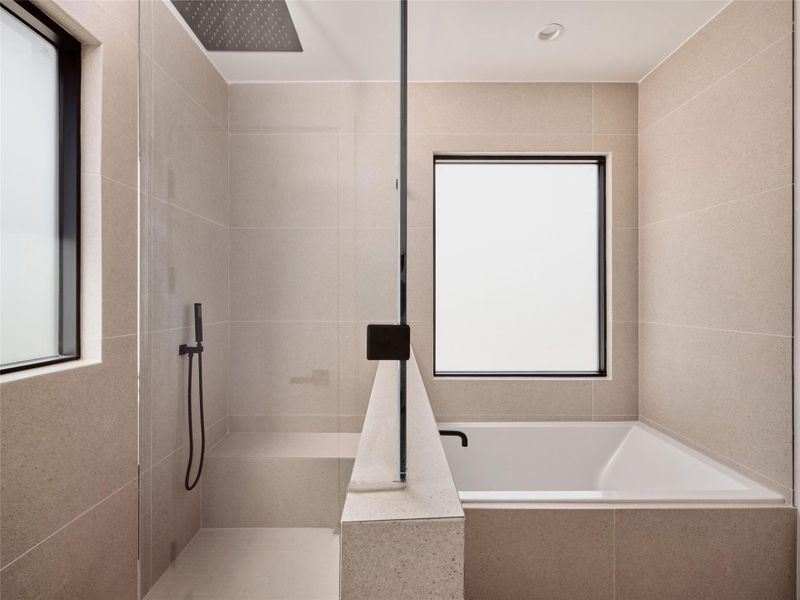 Bathroom featuring a tile shower, tile walls, and a bath