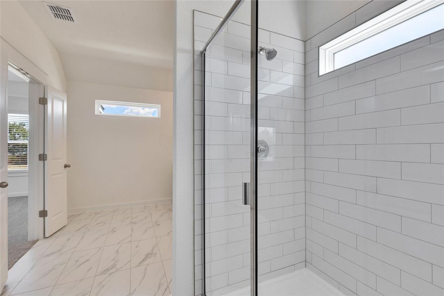 Full bathroom featuring a shower stall and light marble finish floors