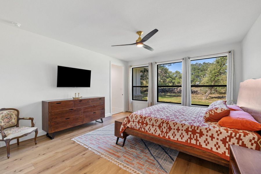 Bedroom with light wood-style flooring and a ceiling fan