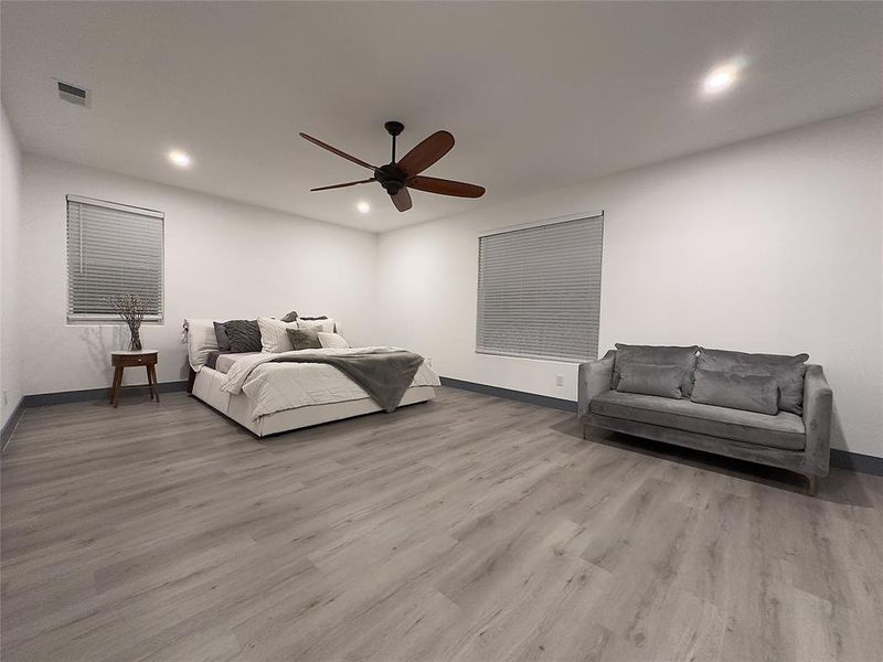 Primary Bedroom wood-type flooring and ceiling fan