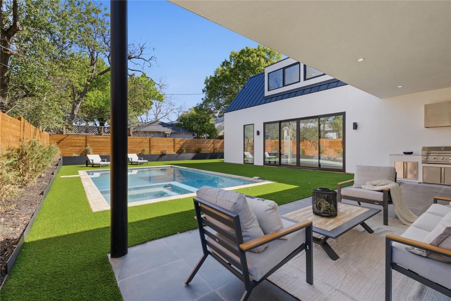 A private backyard oasis showcases a sparkling pool with an integrated spa and an inviting covered patio. A private backyard oasis showcases a sparkling pool with an integrated spa and an inviting covered patio.