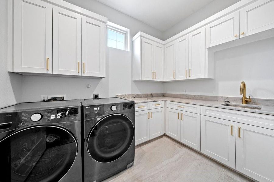 Spacious laundry room with abundant cabinetry, and a built-in sink—combining practicality with polished style to make daily chores a breeze