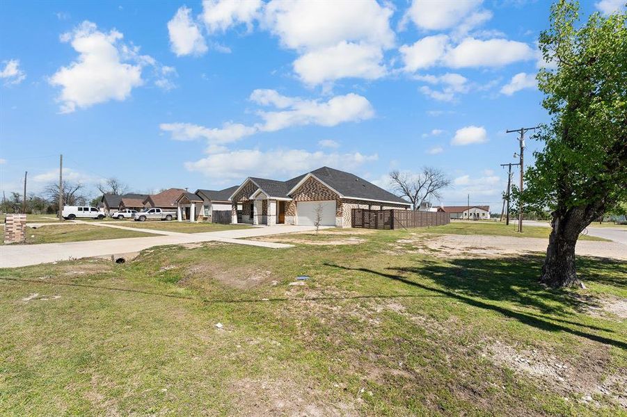View of front of property featuring driveway, an attached garage, and brick siding