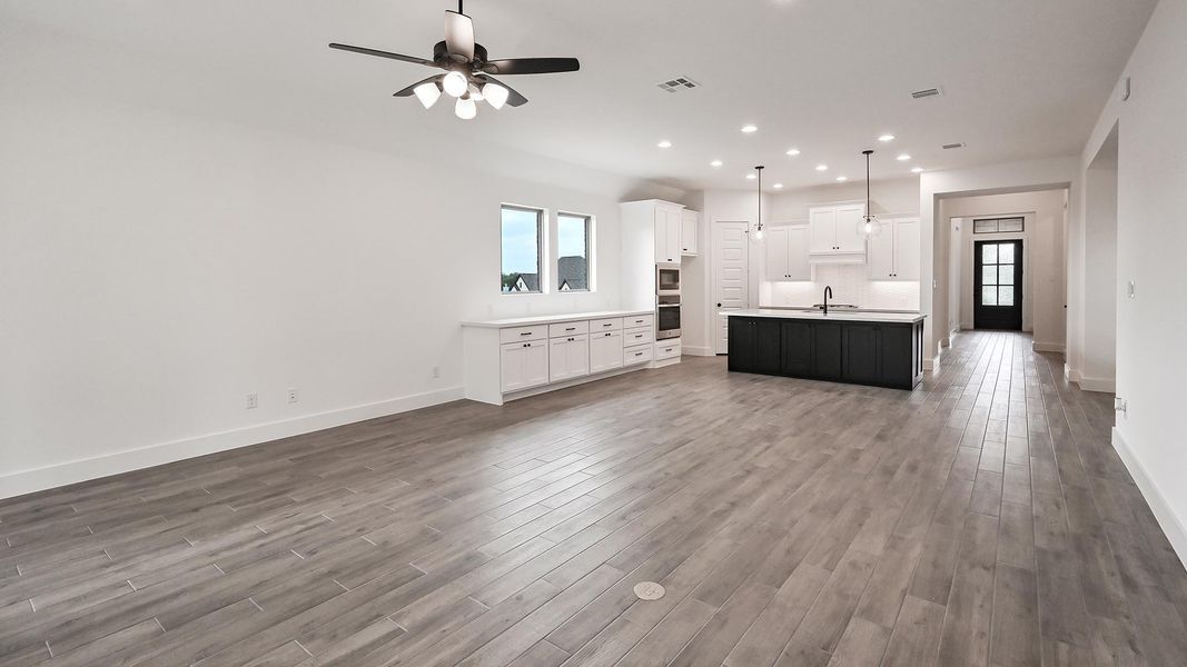 Kitchen with open floor plan, wood finished floors, a sink, and recessed lighting Kitchen with open floor plan, wood finished floors, a sink, and recessed lighting