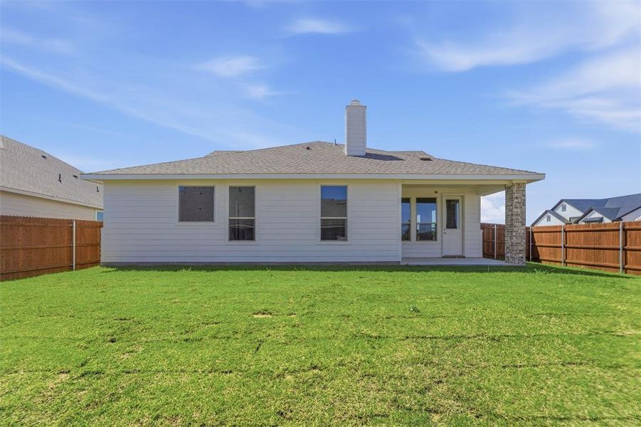 Back of property featuring a patio, a chimney, a shingled roof, and a fenced backyard