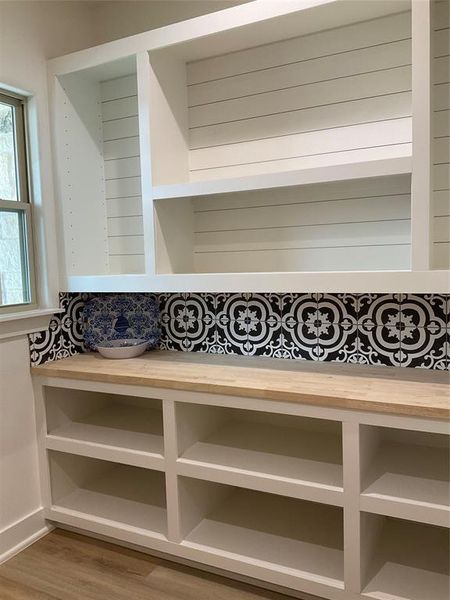 Custom walk in pantry with butcher block counter tops, shiplap, and beautiful backsplash tile